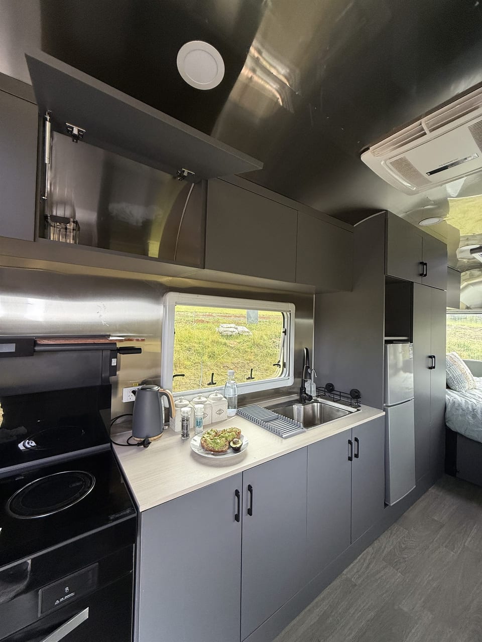 Sink, kitchen worktop, cupboards and appliances inside the caravan