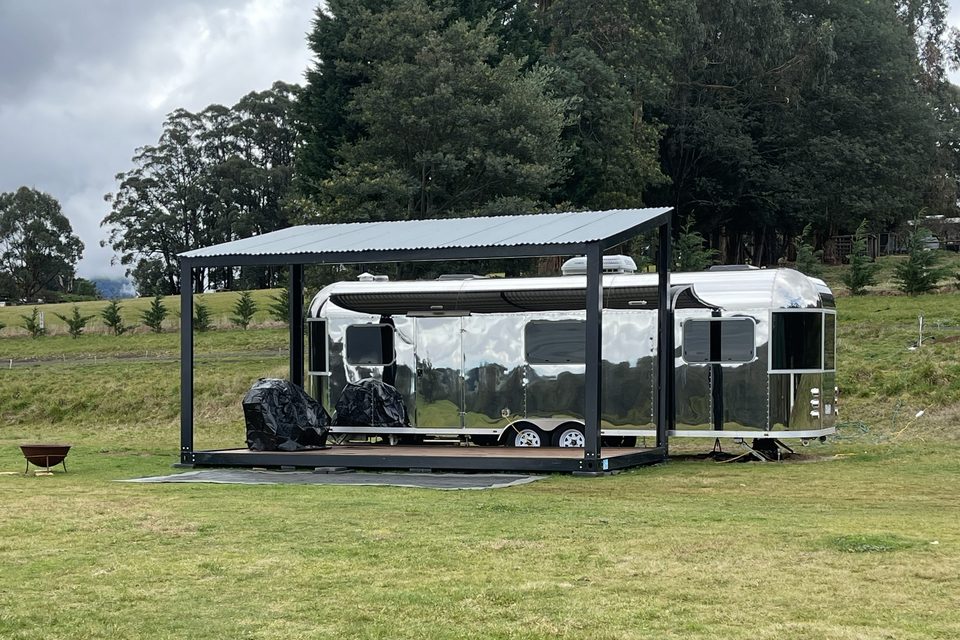 The polished silver caravan beneath its covered pavilion in Rawson