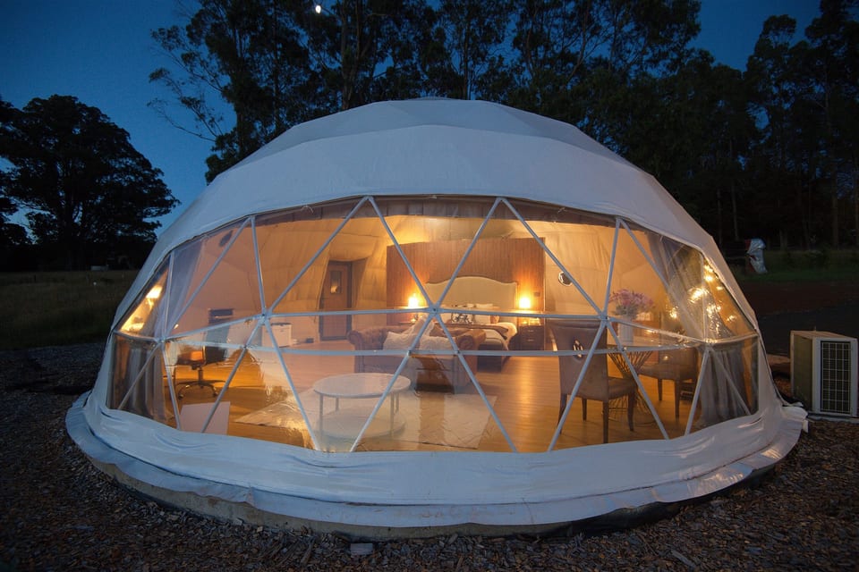 Illuminated dome at dusk, with its curved transparent front
