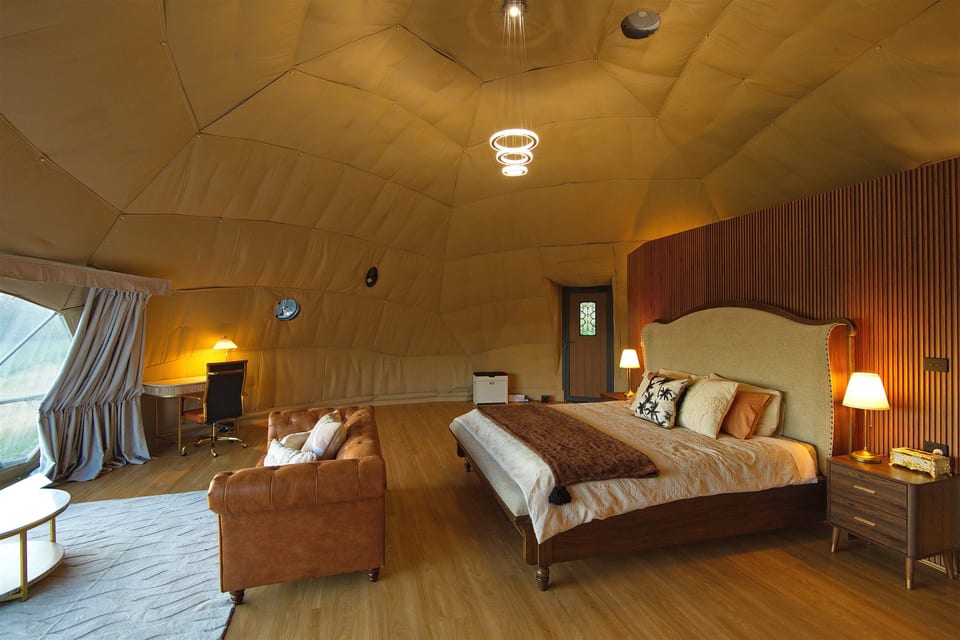Bed and armchairs in the dome's warm, open interior