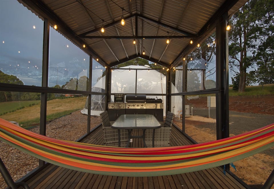 Hammock in front of the covered outdoor kitchen and dining table
